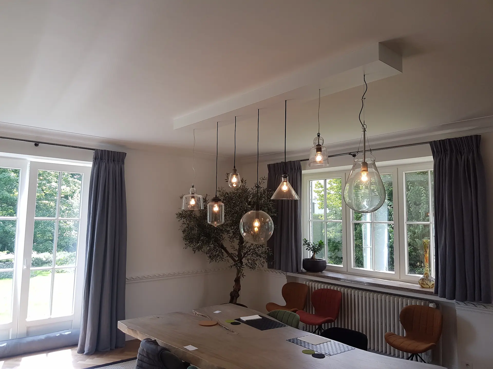 Salle à manger éclairée par des suspensions au-dessus de la table
